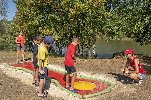 Enfants et adultes jouent au mini-golf au camping CAPFUN Ullule à Tournon d'Agenais (47).