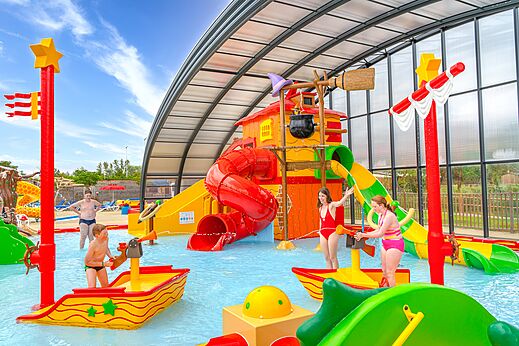 Espace aquatique couvert avec toboggans et jeux d'eau au camping CAPFUN Fort Falabraque à Seltz (67).