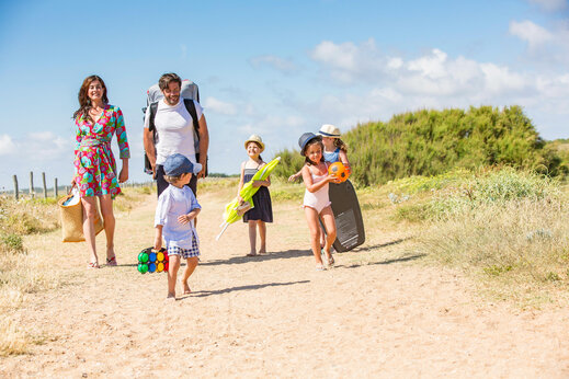 Famille marchant sur chemin de sable vers la plage au camping CAPFUN Loubine à Les Sables d'Olonne (85).
