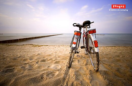 Deux vélos sur une plage de sable fin près de la mer au camping CAPFUN Mer et Soleil à Cap d'Agde (34).
