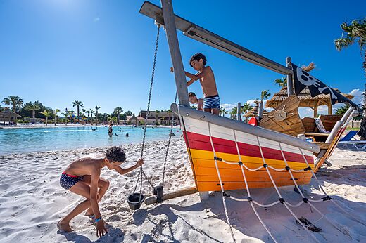 Aire de jeux bateau pirate et piscine lagon au camping CAPFUN La Nautique à Narbonne.