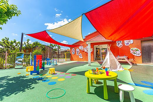 Aire de jeux extérieure colorée avec tables et jeux pour enfants au camping CAPFUN Sagittaire à VINSOBRES (26).